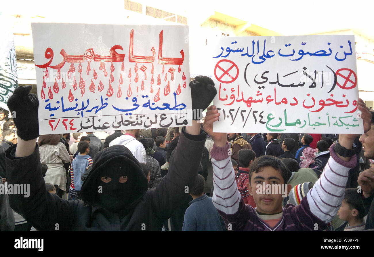 Die Demonstranten halten Schilder während eines Protestes gegen Syriens Präsident Baschar al-Assad in Halab, in Syrien, 24. Februar 2012. Syrische Truppen die Rebellen Hochburg in Leonberg für die 22. gerade Tag beschossen, nach einer Pause erlaubt die Helfer einige Zivilisten zu evakuieren, Monitore, sagte. UPI Stockfoto