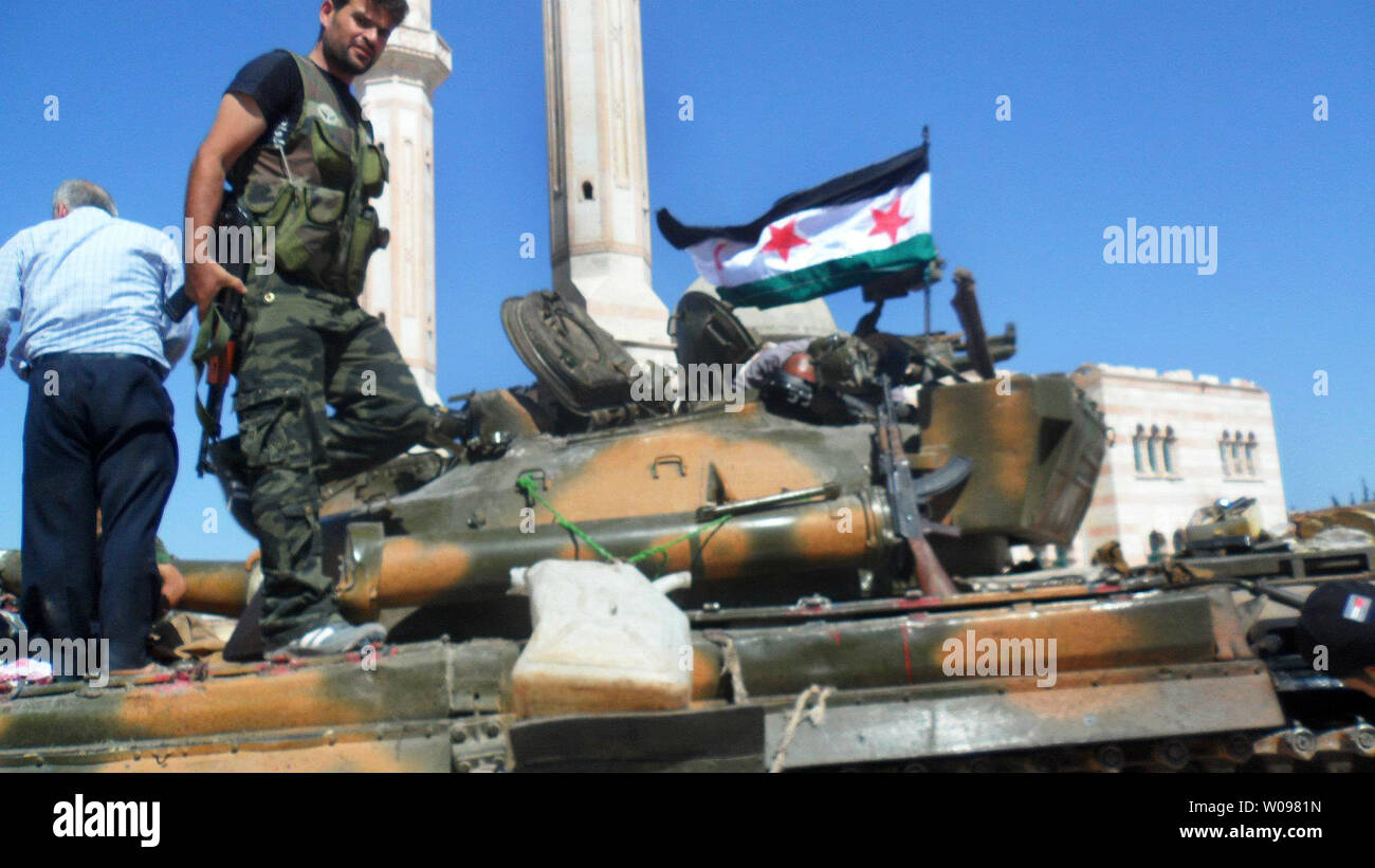 Freie Syrische Armee Mitglieder feiern die Mitglieder der Freien Syrischen Armee stand auf einem Tank einen Tag nach dem Syrischen Verteidigungsminister war, die bei dem Anschlag in Damaskus in Aleppo in Syrien am 19. Juli 2012 ermordet. UPI/Khaled Tallawy Stockfoto
