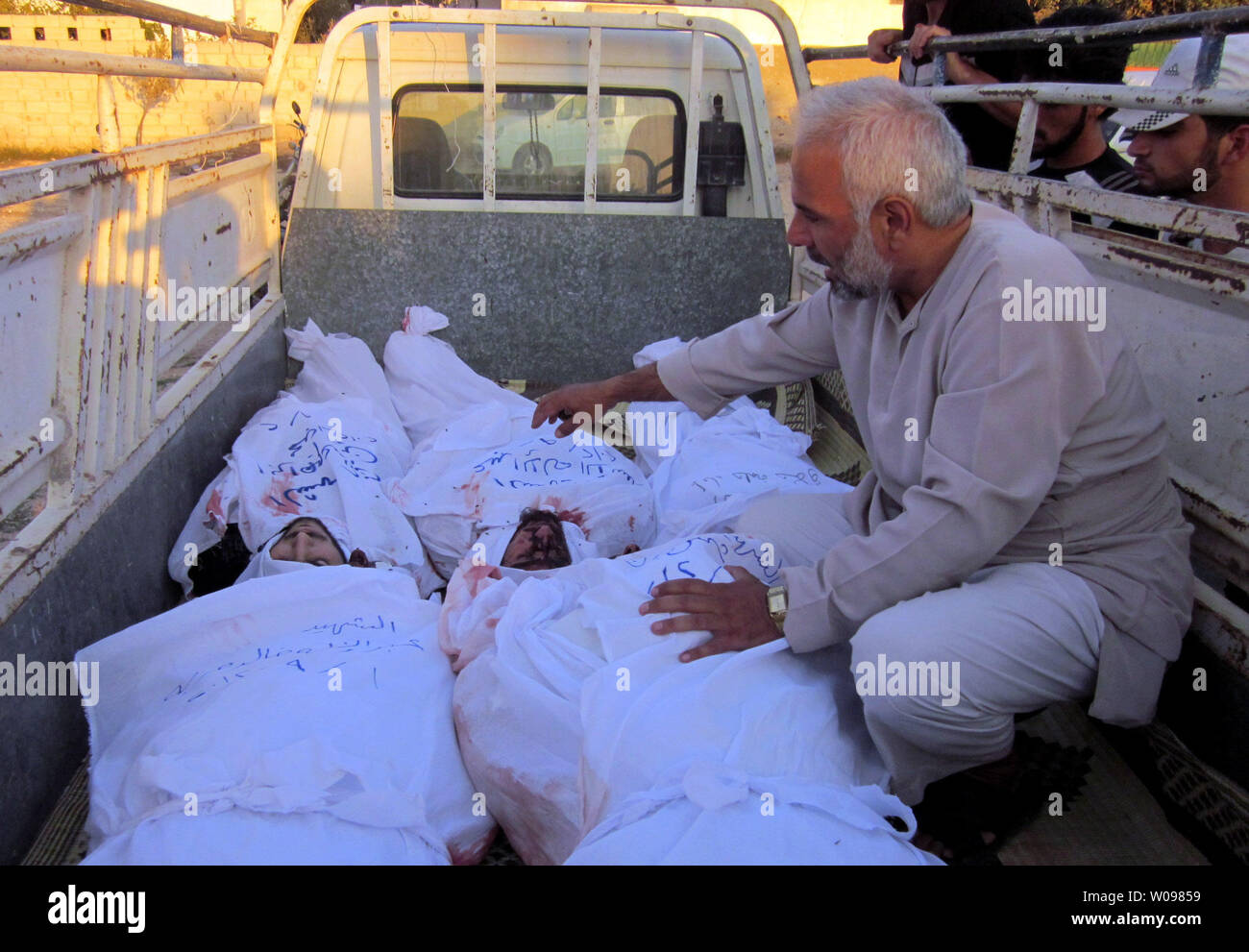 Ein Bewohner betrachtet Körper, den Aktivisten sagen, durch Truppen Syrien Präsident Bashar al-Assad, vor ihrer Beerdigung an Qusseer in der Nähe von Homs im September 2, 2012 getötet wurden, den Streitkräften der Regierung auch eine Reihe von Bereichen, im Norden Syrien Teil der Bemühungen, die vom Regime rebel Festungen. Truppen verwendet Ebenen mehrere Wohnungen in Aleppo, der Syrischen Beobachtungsstelle für Menschenrechte zu schlagen. UPI Stockfoto