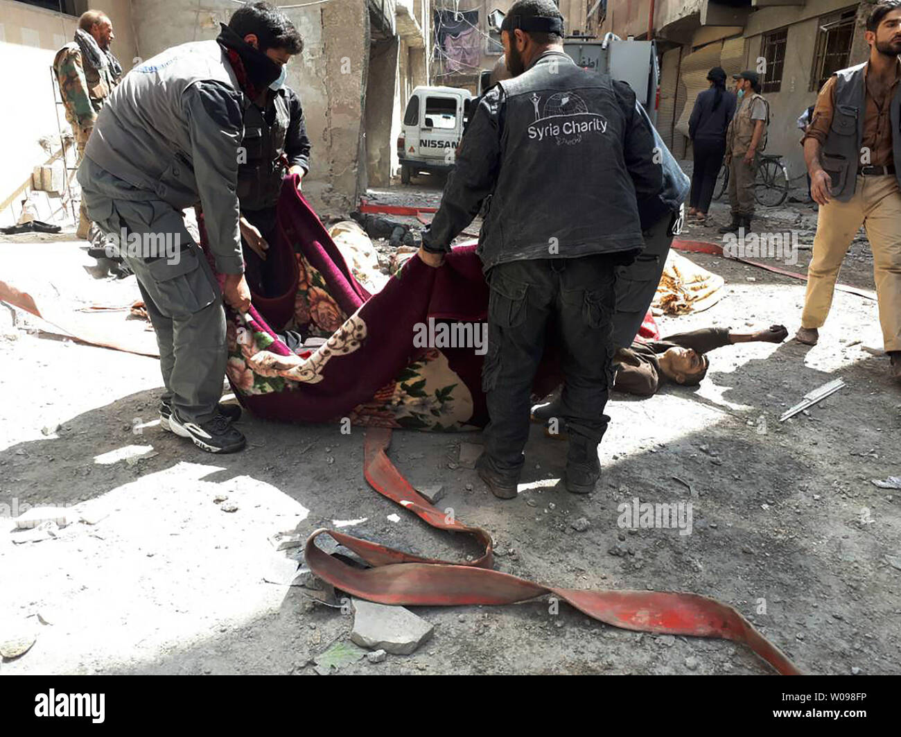 *** Herausgeberanmerkung INHALT *** syrischer Männer, die Leichen der Zivilisten, nachdem ein angeblicher chemischer Angriff auf die Rebellen gehaltene Stadt Douma in Syrien. Mindestens 78 Zivilisten, darunter Frauen und Kinder, starben nach ersten Ergebnissen. Foto von Mohammed Hassan/UPI Stockfoto