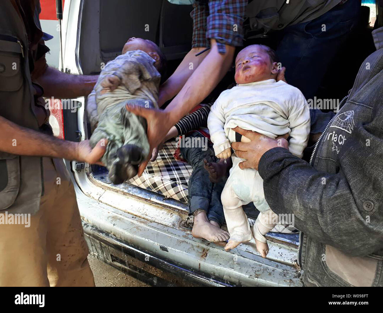 *** Herausgeberanmerkung INHALT *** syrischer Männer, die Leichen der Kinder tragen, nachdem ein angeblicher chemischer Angriff auf die Rebellen gehaltene Stadt Douma in Syrien. Mindestens 78 Zivilisten, darunter Frauen und Kinder, starben nach ersten Ergebnissen. Foto von Mohammed Hassan/UPI Stockfoto