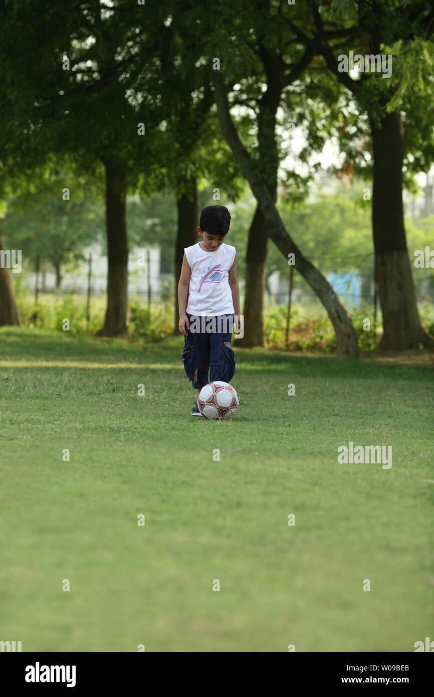 Jungen spielen Fußball in einem Feld Stockfoto