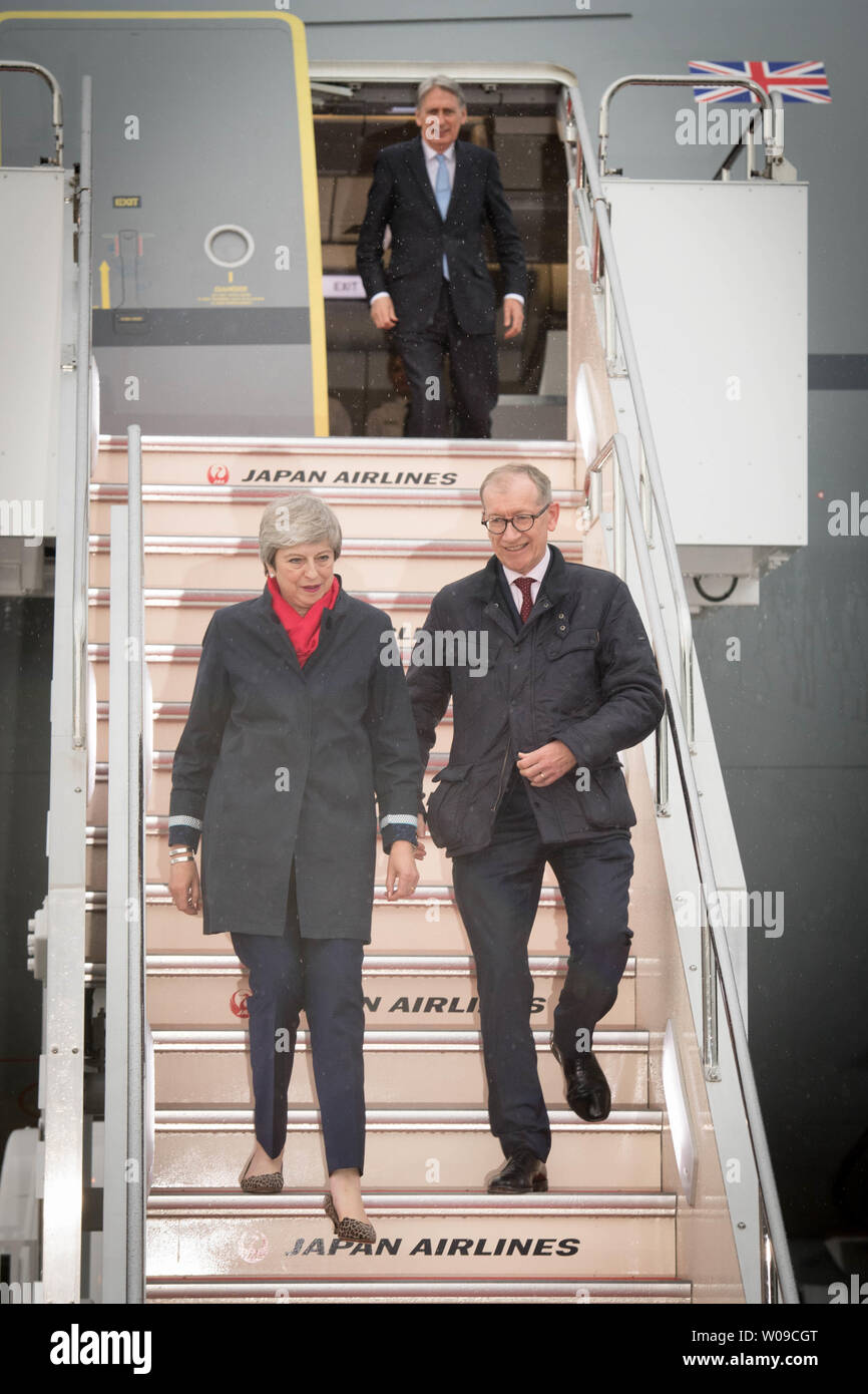 Premierminister Theresa May geht hinunter die Schritte von ihrer Flugzeuge mit ihrem Ehemann, Philip, beobachtet von den Kanzler, Philip Hammond (oben), nach der Ankunft in Osaka in Japan für den G20-Gipfel. Stockfoto