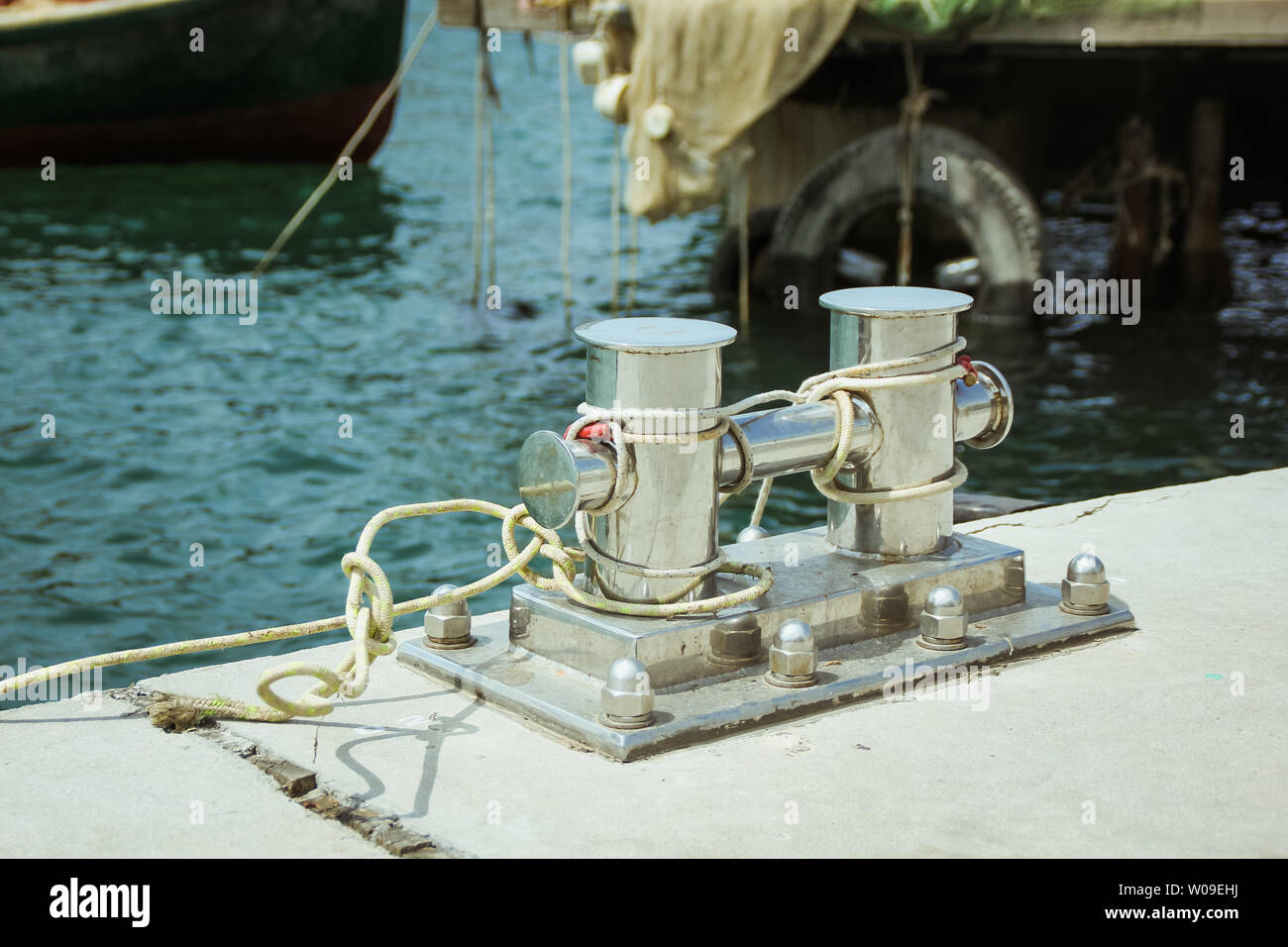 Liegeplatz Poller, Seil mit Liegeplatz im Hafen in der Bucht verflochten Stockfoto
