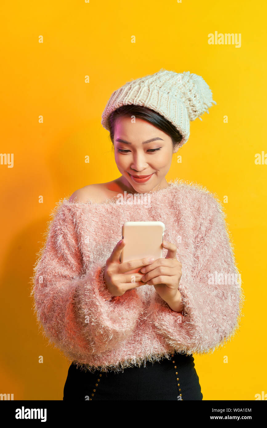 Elegante junge Frau mit Sonnenbrille und trägt weichen Pelz auf dem Telefondisplay. Stockfoto