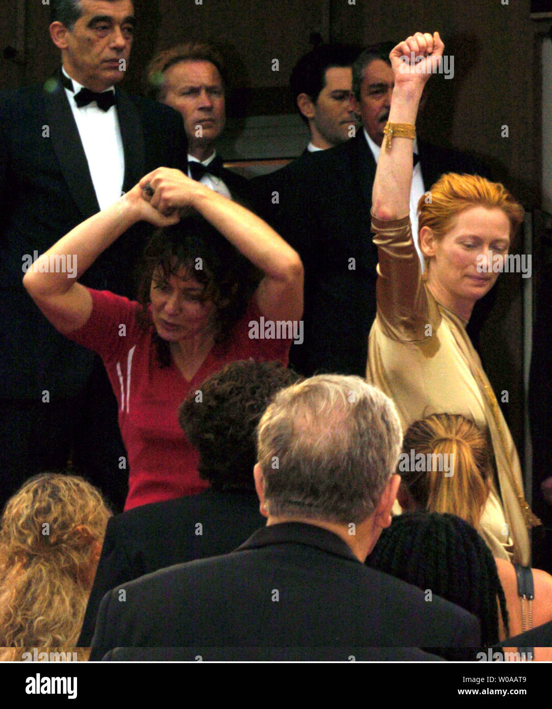Schauspielerin Tilda Swinton (rechts) wirft eine geballte Faust, wie sie oben geht die Treppen am Palais des Festival zur Unterstützung einer der Demonstranten von Les Intermittents, einer Union der Teilzeitbeschäftigten in der französischen Filmindustrie, die einer friedlichen Demonstration auf dem Roten Teppich vor dem Screening von Pedro Almodovar Film "schlechte Erziehung" in der Eröffnungsnacht des Cannes Film Festival in Cannes am 12. Mai 2004 veranstaltet. Die Europäische Union ist bestrebt, die Leistungen bei Arbeitslosigkeit für ihre Mitglieder von der französischen Regierung und musste von der Festivalleitung eingeladen worden, um zu verhindern, dass das Screening ein mehr Seri zu besuchen Stockfoto