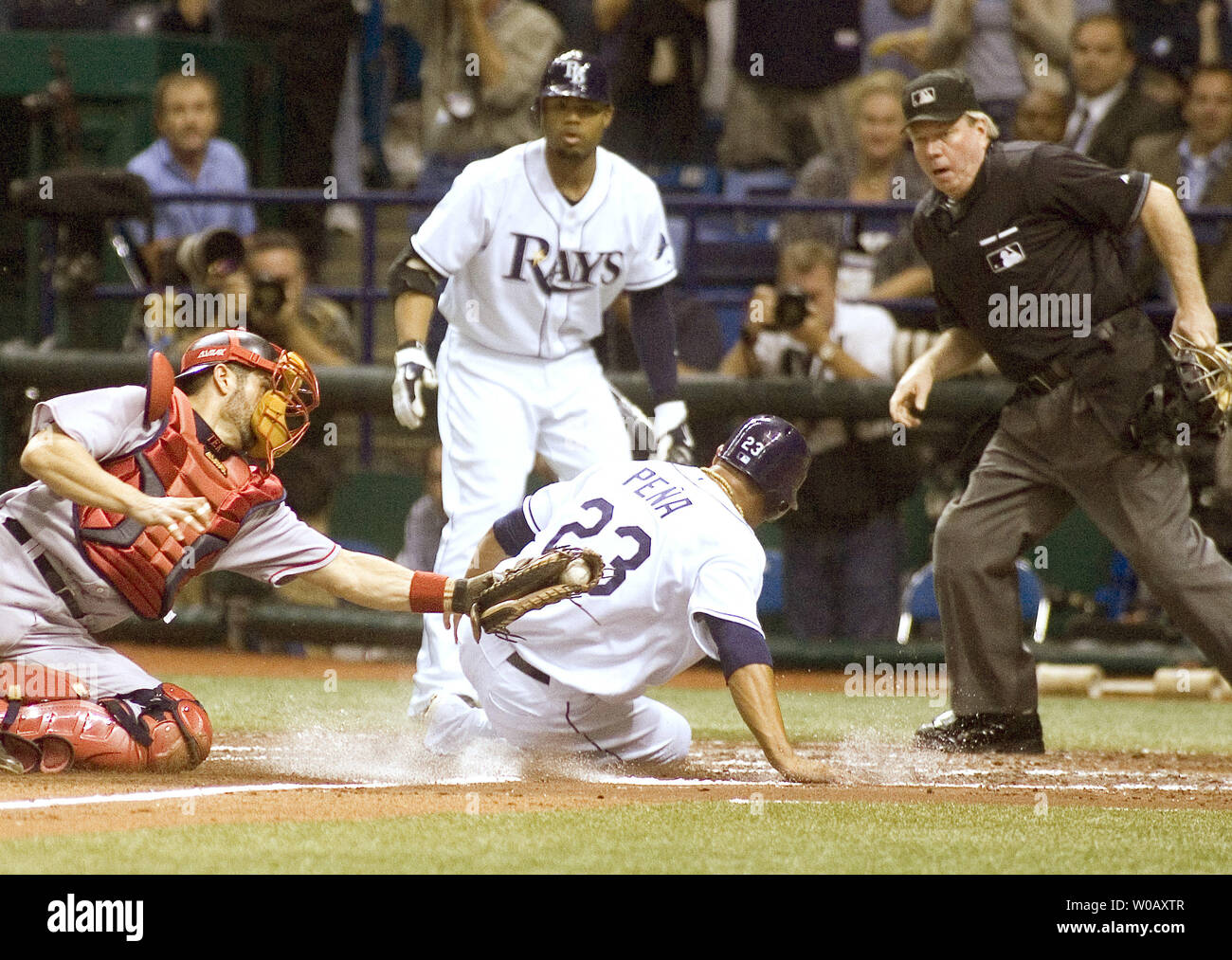 Tampa Bay Rays Carlos Pena Folien sicher Vergangenheit Boston Red Sox catcher Jason Varitek die Strahlen zu Geben eine Leitung 2-1 ein Evan Longoria double im vierten Inning während des Spiels sieben der American League Championship Series im Tropicana Field in St. Petersburg, Florida am 19. Oktober 2008. Strahlen Carl Crawford Uhren als Home Plate Umpire Brian Gorman den Anruf macht. (UPI Foto/David Mills) Stockfoto