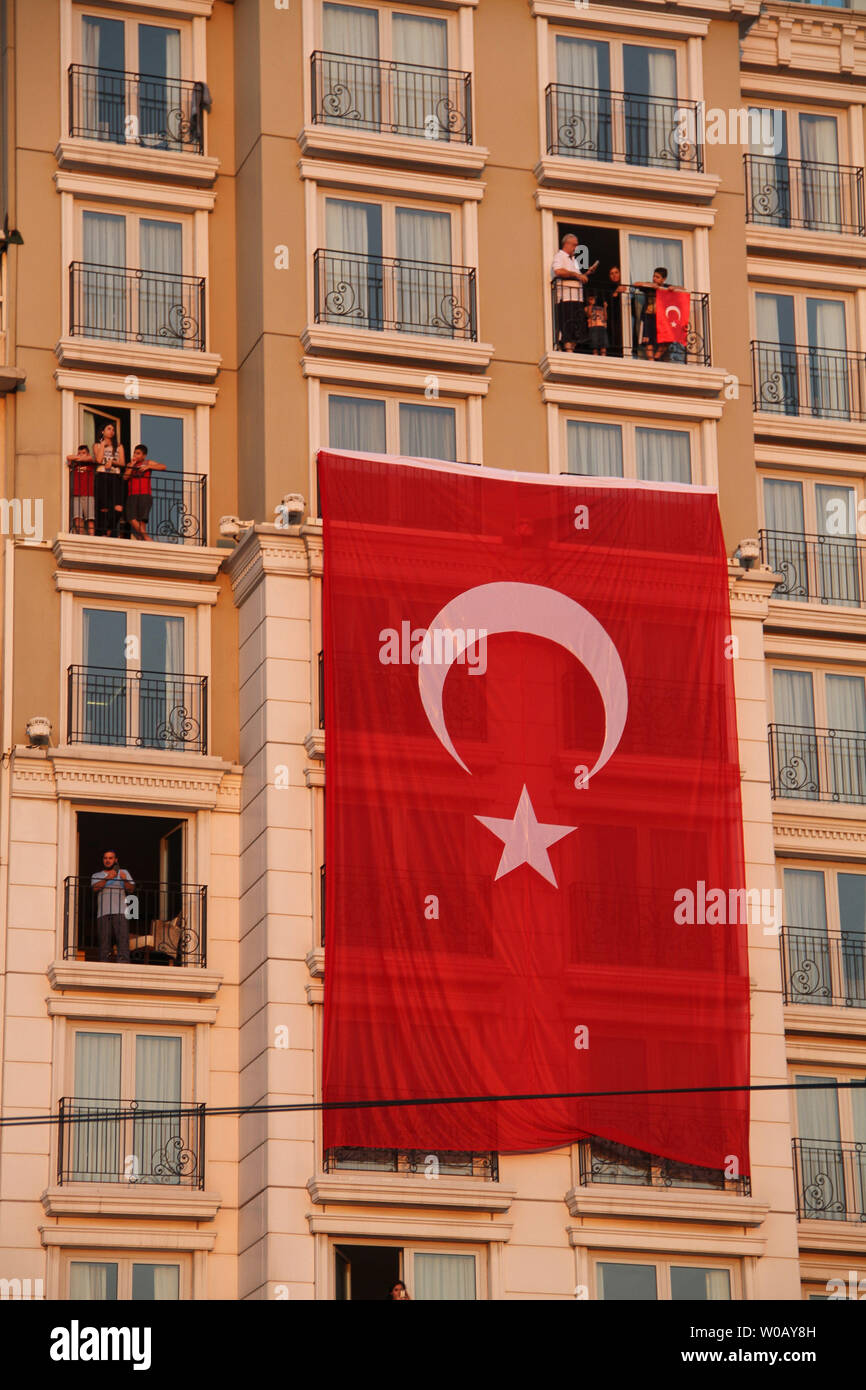 Eine Türkische Flagge hängt an einem Gebäude in Taksim Square während einer Demonstration zur Unterstützung der türkischen Präsidenten in Istanbul in der Türkei am 16. Juli 2016. Präsident Recep Tayyip Erdogan kämpfte die Kontrolle über die Türkei am 16. Juli 2016 zu bekommen, nachdem ein Putsch, mehr als 250 Leben, geführt von unzufriedenen Soldaten in der Armee behauptete. Foto von Hanna Noori/UPI Stockfoto