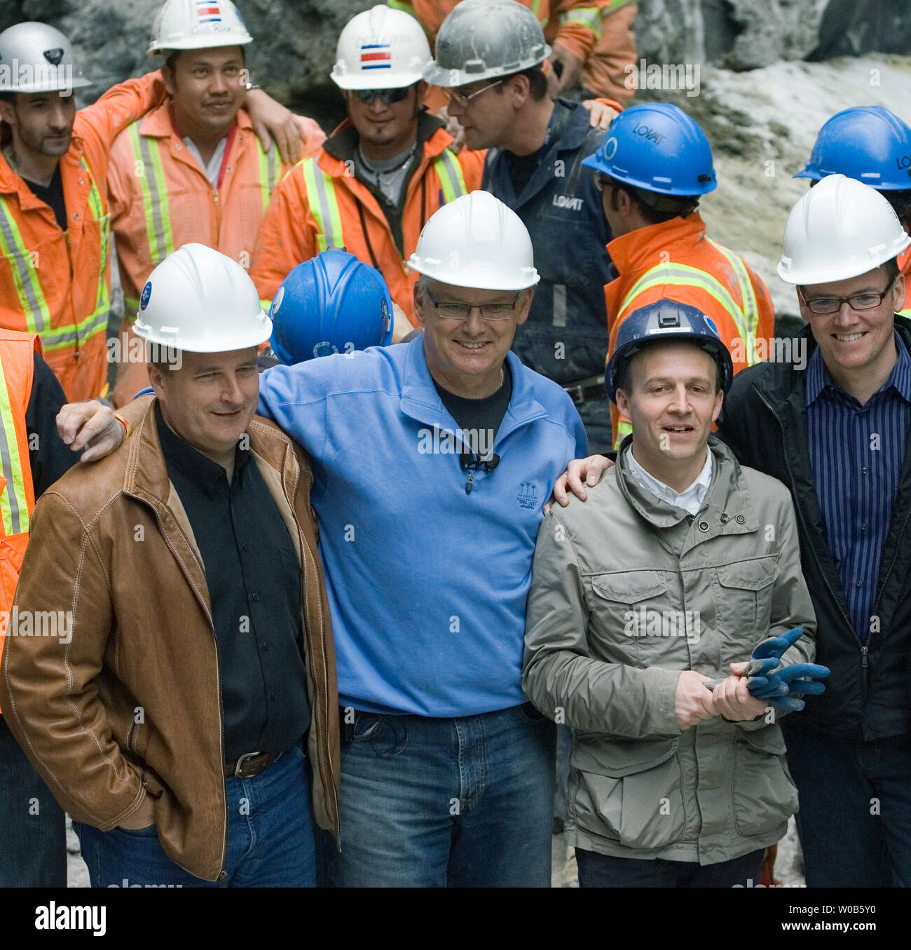 British Columbia (BC) Premier Gordon Campbell (Mitte links) und Projektleiterin Andrea Ciamei aus Italien (Mitte rechts) zusammen mit lokalen Würdenträgern Bauarbeiter feiern nach einer Erde Druckausgleich Tunnelbohrmaschine (EPB TBM), 86 Meter in der Länge, 6,1 Meter Durchmesser und einem Gewicht von 440 Tonnen durch eine verbleibende Zylinder von Rock nördlich von Pender Street bei Granville während einer Veranstaltung in Anerkennung der Abschluss der Ersten der gekoppelten Tunnel für die rapid transit Kanada Linie in der Innenstadt von Vancouver, BC, April 7, 2007 brach. Die EPB TBM ist Laser geführte und präzise mit Stockfoto