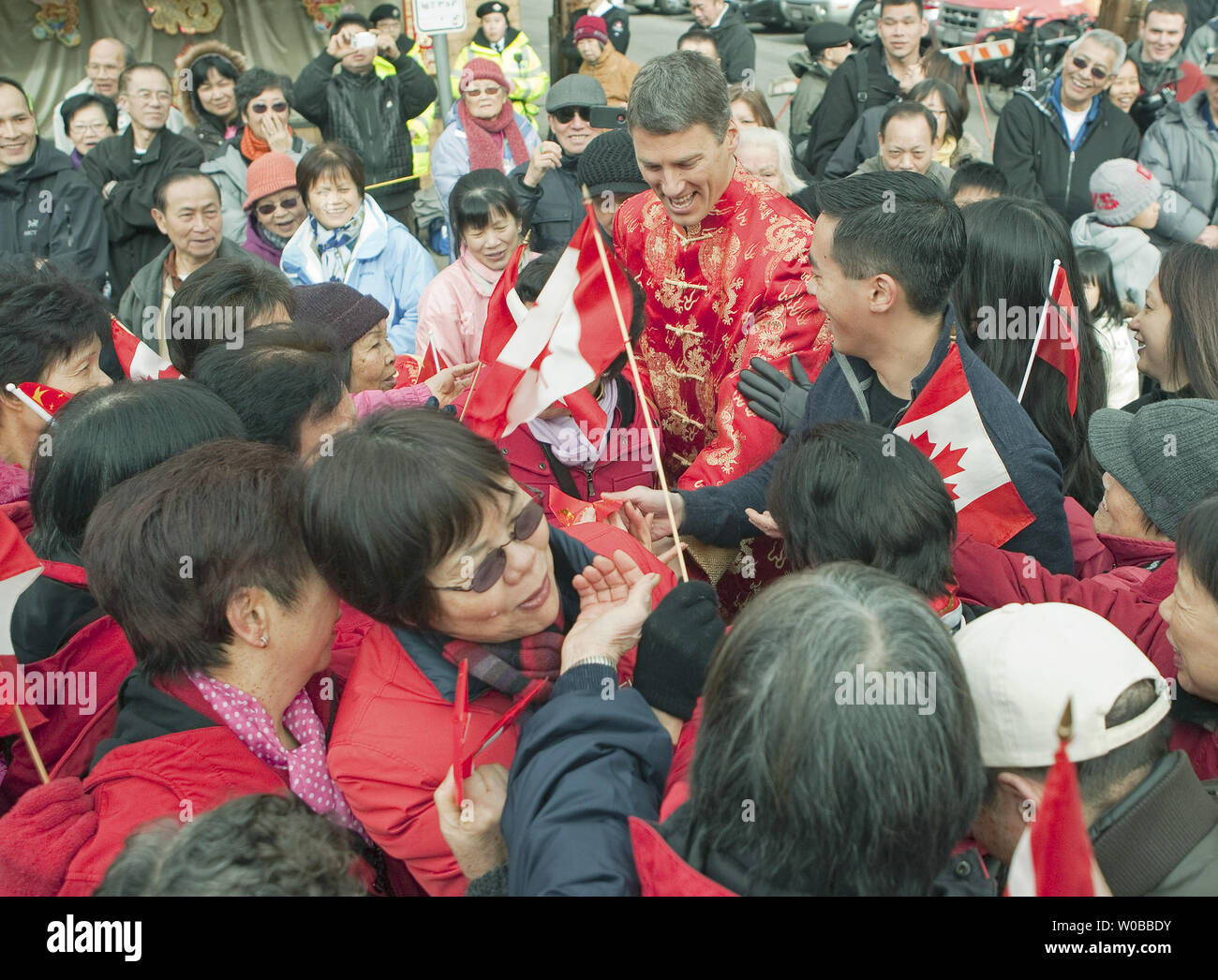 Vancouver Oberbürgermeister Gregor Robertson ist gemobbt, als er die Hände, rote 'Glück' Geld Pakete in Chinatown während des 2013 Chinese New Year Parade, feiert die "Jahr der Schlange" in Vancouver, British Columbia (BC), 17. Februar 2013. Über 50.000 Zuschauer stellte sich heraus, dass für diese 40. jährliche Parade in der Drittgrößten Chinatown in Nordamerika. UPI/Heinz Ruckemann Stockfoto