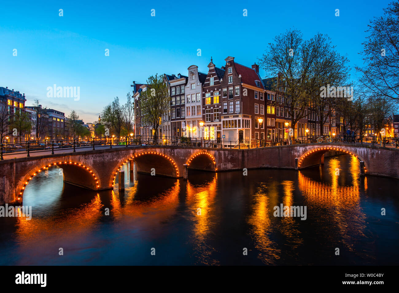 Kanäle von Amsterdam in der Nacht. Amsterdam ist die Hauptstadt und die bevölkerungsreichste Stadt der Niederlande. Stockfoto