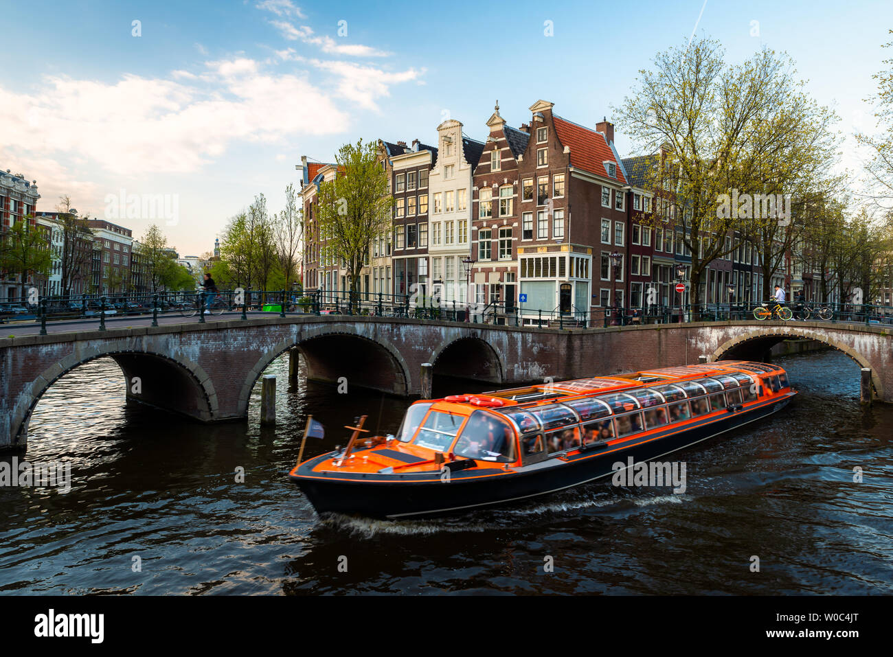Amsterdam Grachtenfahrt Schiff mit traditionellen Haus der Niederlande in Amsterdam, Niederlande. Stockfoto