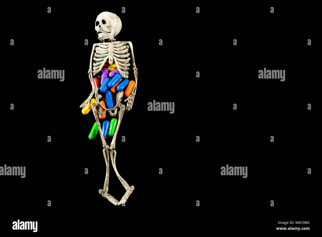 Menschliche wie Gummi Skelett mit farbigen Pillen innen ist, konzeptuelle Bild über Gesundheit, Krankheit und pharmazeutische Industrie Stockfoto