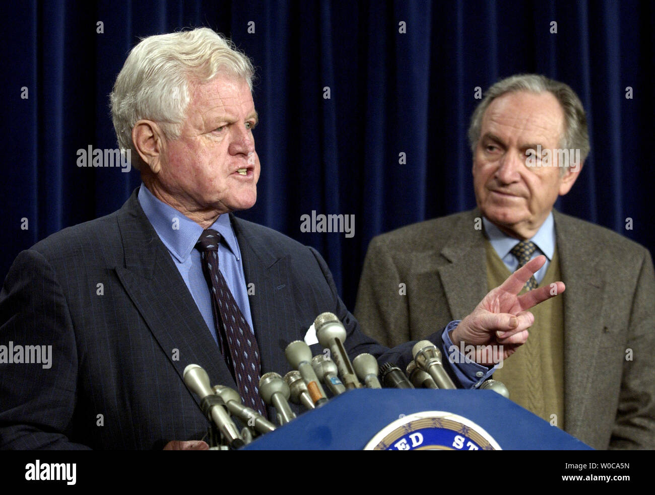 Senator Ted Kennedy, D-Masse, Adressen Mitglieder der Presse, als Tom Harkin, D-IA, auf, während einer Pressekonferenz auf der Omnibus Rechnung schaut, am 20. Januar in Washington 2004. Kennedy und Harkin beide sagten, dass sie für die Rechte der Arbeitnehmer und die Erhöhung des Mindestlohns kämpfen würde. (UPI Foto/Michael Kleinfeld) Stockfoto