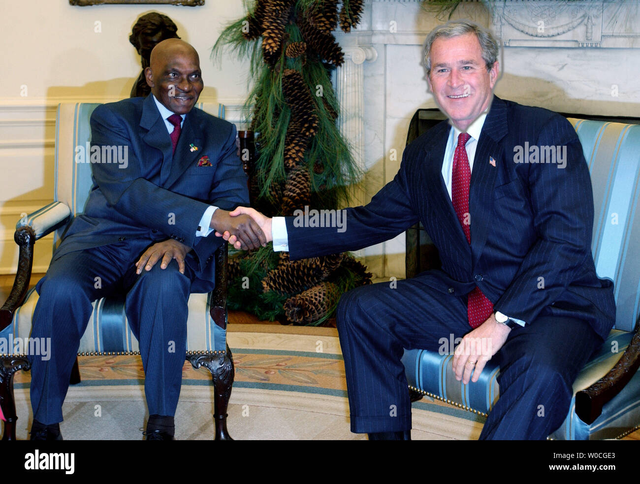 Präsident George W. Bush begrüßt Senegals Präsident Abdoulaye Wade, der das Oval Office am 6. Dezember 2004 im Weißen Haus in Washington. (UPI Foto/Michael Kleinfeld) Stockfoto