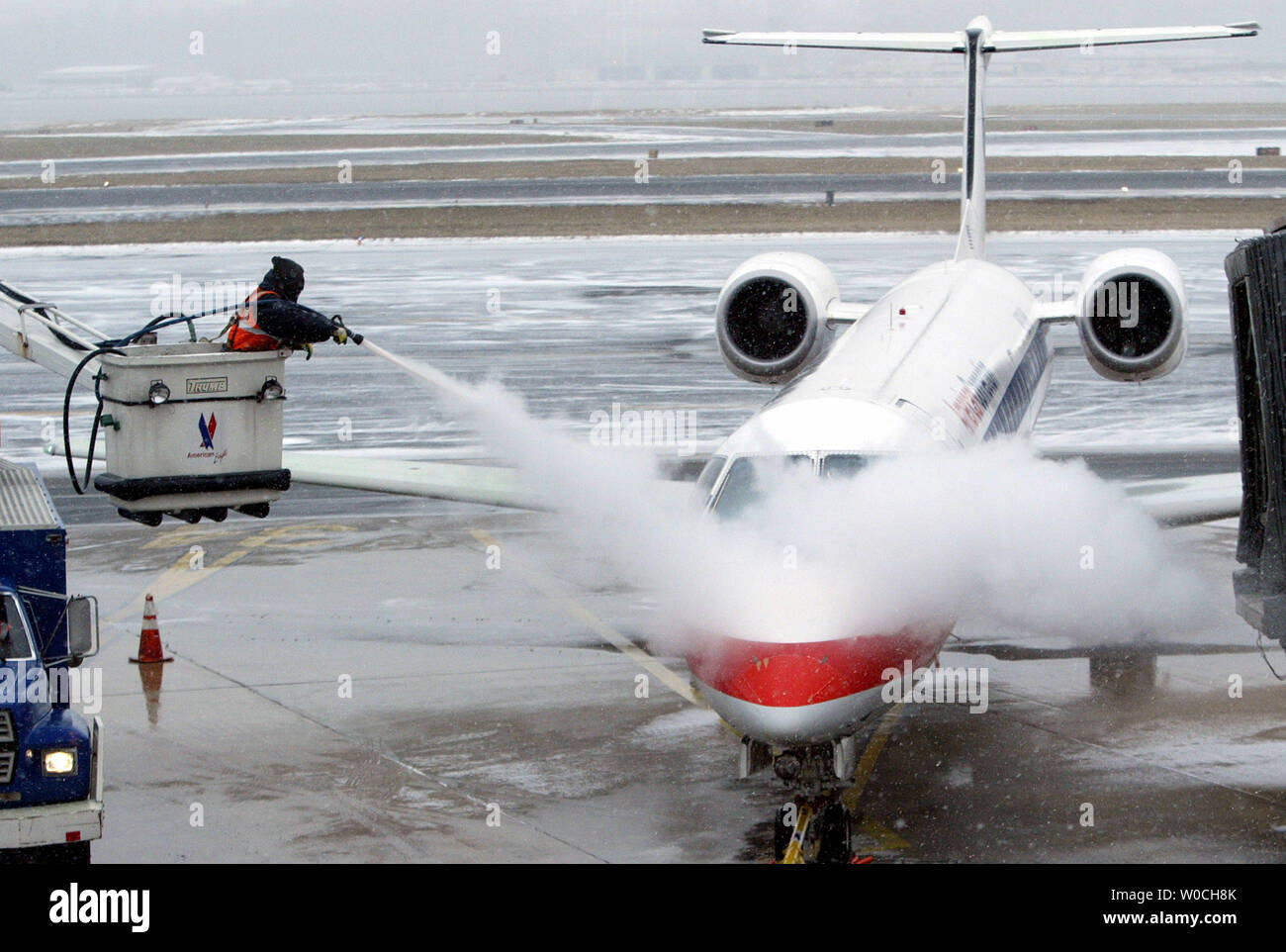 Ein Arbeiter Sprays eine American Eagle Regional Jet mit Heckscheibenheizung, die sich anschickt, bei leichtem Schneefall am nationalen Flughafen Ronald Reagan in Alexandria, VA am 22. Januar 2005 zu nehmen. Forcasters prognostizieren einen intensiven winter storm mit möglichen Schneefall über 12 Zoll für die Ostküste. (UPI Foto/Rechnung Greenblatt) Stockfoto