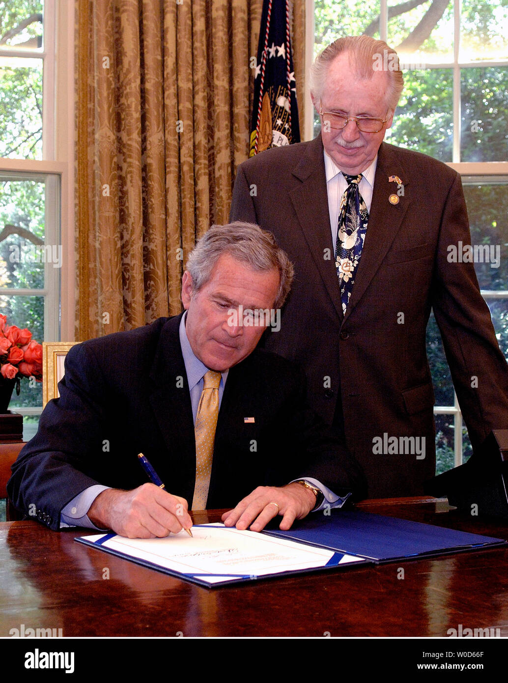 Präsident George W. Bush unterzeichnet H.R. 42, die Freiheit der amerikanischen Flagge Act von 2005, im Oval Office des Weißen Hauses in Washington am 24. Juli 2006 anzuzeigen. Bush war verbunden von Kongreßabgeordneten Roscoe Bartlett (R-MD) Stockfoto