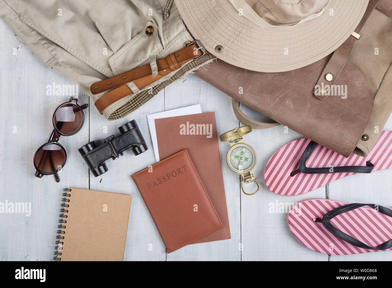 Vorbereitung für Reise in Afrika Style - Zubehör und Reiseutensilien, Verpackung Kleidung im Rucksack: Rucksack, Mütze, Reisepass, Flip Flops, Sonnenbrille, Komp Stockfoto