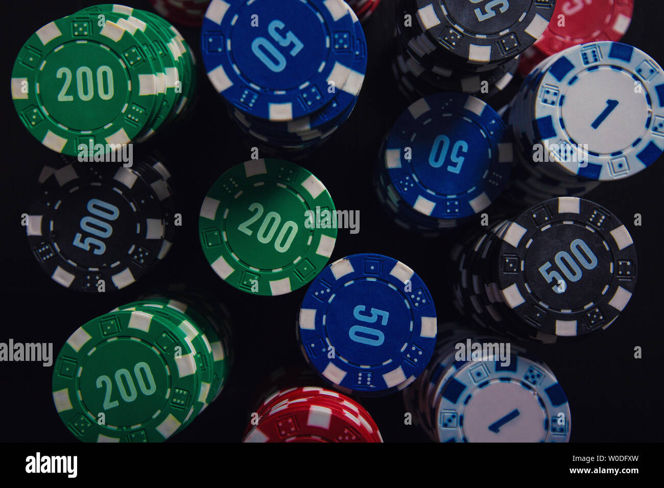 Close up Stack von verschiedenen farbigen poker chips unterschiedlicher Wert  auf den Schwarzen Tisch Hintergrund isoliert. Spielen Turnier Wetten für  Erfolg Stockfotografie - Alamy