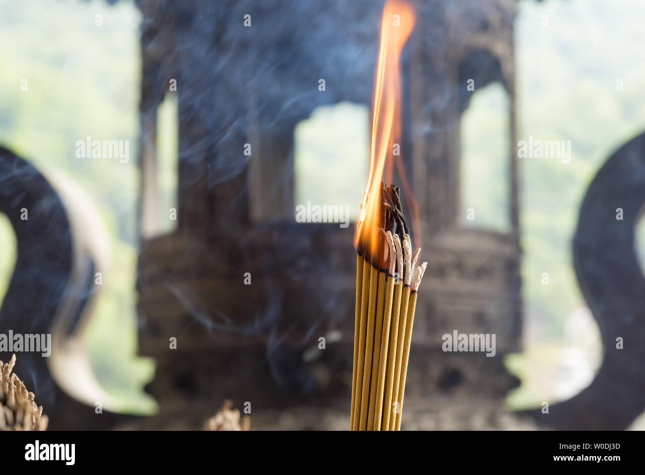 Räucherstäbchen mit unscharf Buddhistischen Tempel im Hintergrund. Stockfoto