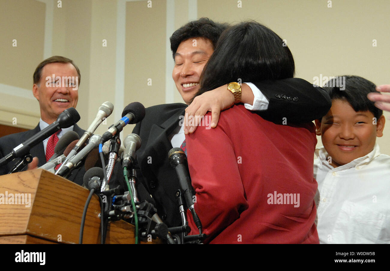 Chinesischer Aktivist Yang Jianli umarmt seine Frau Christina Fu nach dem Gespräch über die Rückgabe nach einem fünf Jahre Haft in China auf dem Capitol Hill in Washington am 21. August 2007 in die USA. Am Recht ist sein Sohn Aaron und Links ist sek Vorsitzender Chris Cox. Yang Jianli, einer der Demonstranten auf dem Platz des Himmlischen Friedens, wurde 2002 nach der Rückkehr nach China Labour Unruhen zu beobachten verhaftet. (UPI Foto/Roger L. Wollenberg) Stockfoto