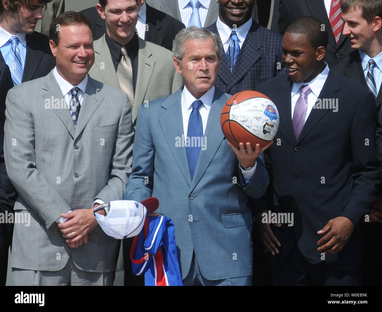 Präsident George W. Bush hält einen Basketball als er steht mit Kansas Universität Basketball guard Russell Robinson (R) und Haupttrainer Rechnung Selbst (L) wie Er ehrt den 2008 NCAA Men's National Basketball Championship Team von der Universität von Kansas während einer Zeremonie im Rosengarten des Weißen Hauses in Washington am 3. Juni 2008. (UPI Foto/Kevin Dietsch) Stockfoto