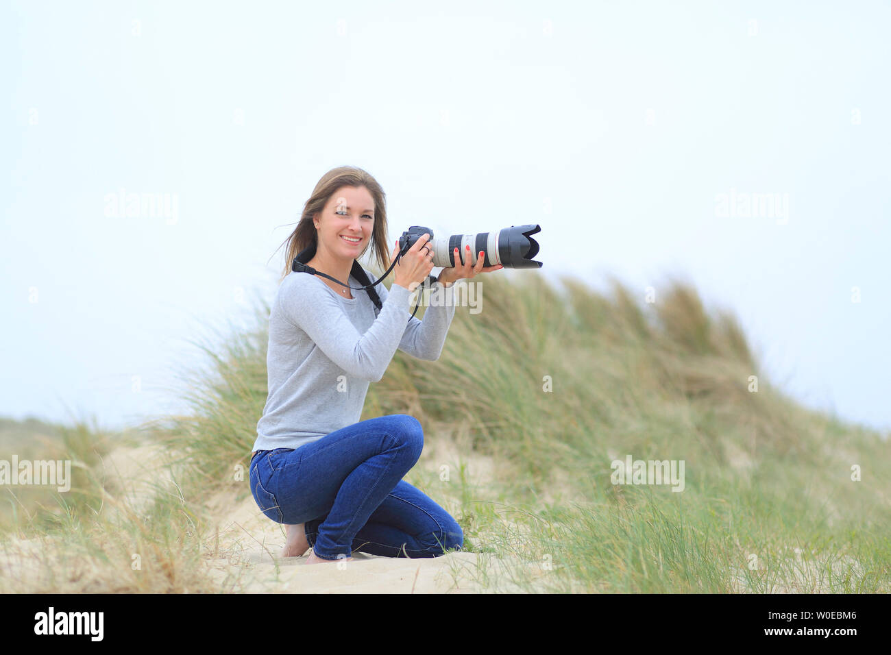 Junge Frau Fotos am Strand Stockfoto