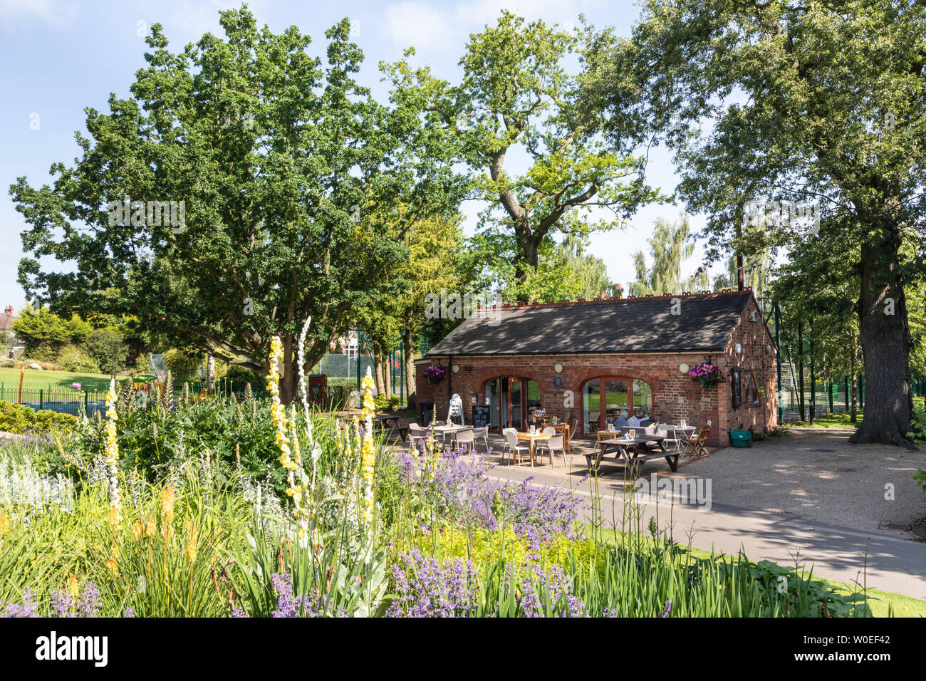Rugby Warwickshire, Großbritannien: Das Tool Shed Cafe mit Sitzgelegenheiten im Freien befindet sich in einem kleinen Ziegelgebäude, das zwischen Bäumen und Blumen im Caldecott Park liegt. Stockfoto