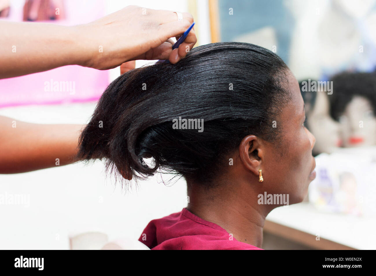 Der Friseur Kämmen Sie das Haar ihrer Kunden bevor Sie fortfahren, Shap ihres Haares zu setzen. Stockfoto