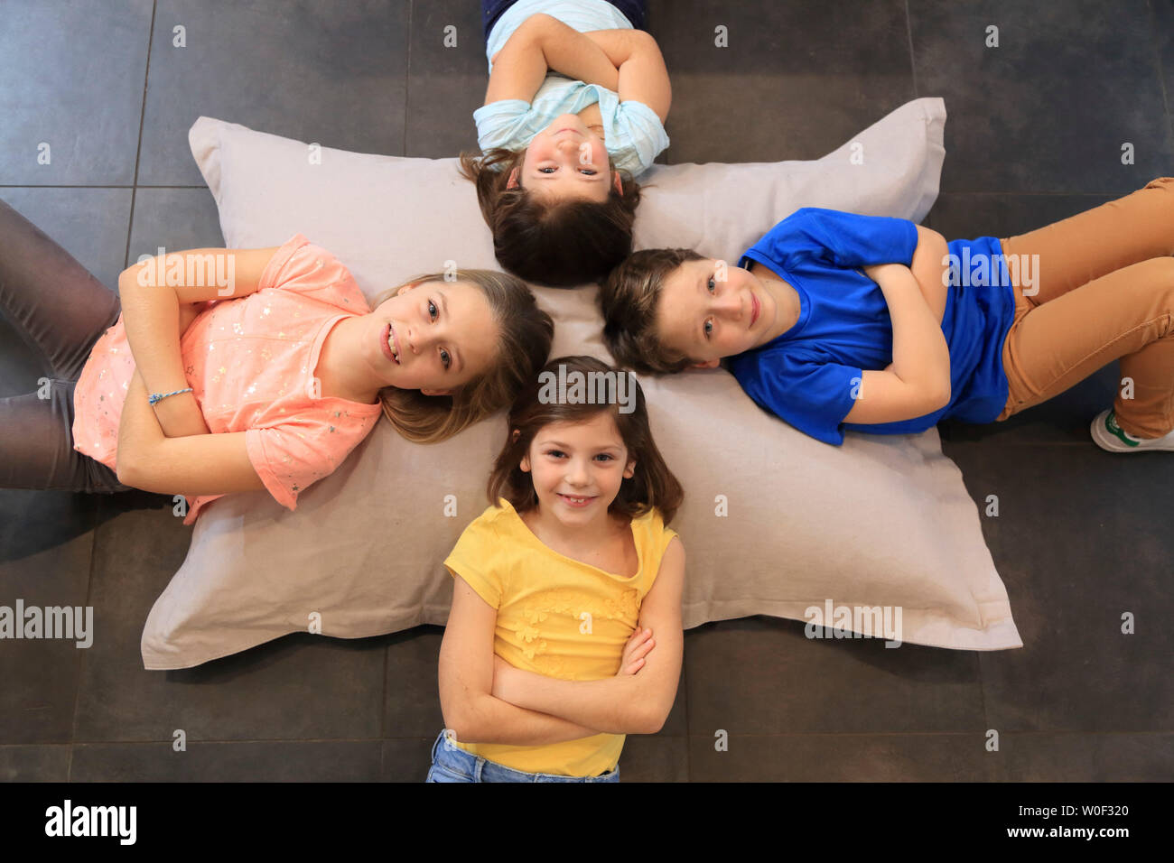 Vier Kinder auf einem grossen Kissen Stockfoto