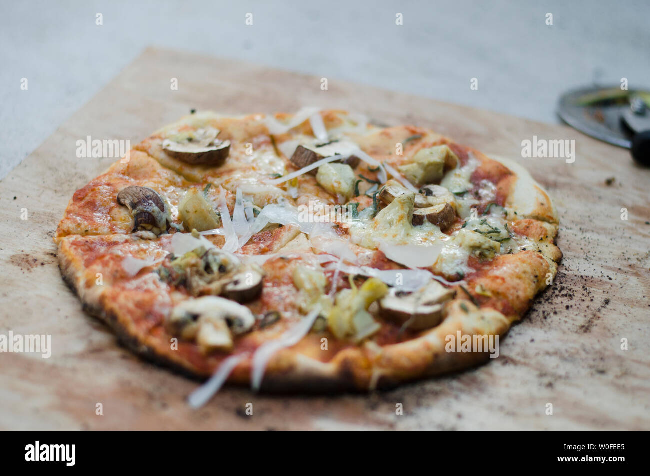 Rustikale Pizza auf Holz- Schiefer Stockfoto