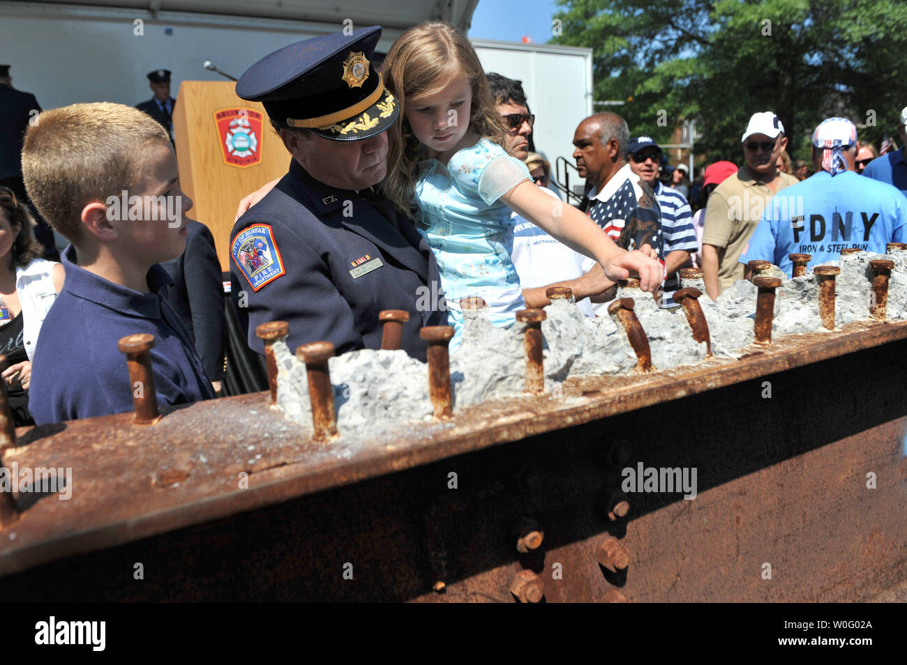 Fairfax City Assistant Fire Chief Tim Butters und seine dughter Emily Blick an einem Stück Stahl aus dem World Trade Center, die dem Arlington County Fire Department von New York City Fire Department als ein Geschenk der Vielen Dank für Ihren Service auf 9/11, in Arlington, Virginia, am 29. August 2010 erteilt wurde. UPI/Kevin Dietsch Stockfoto