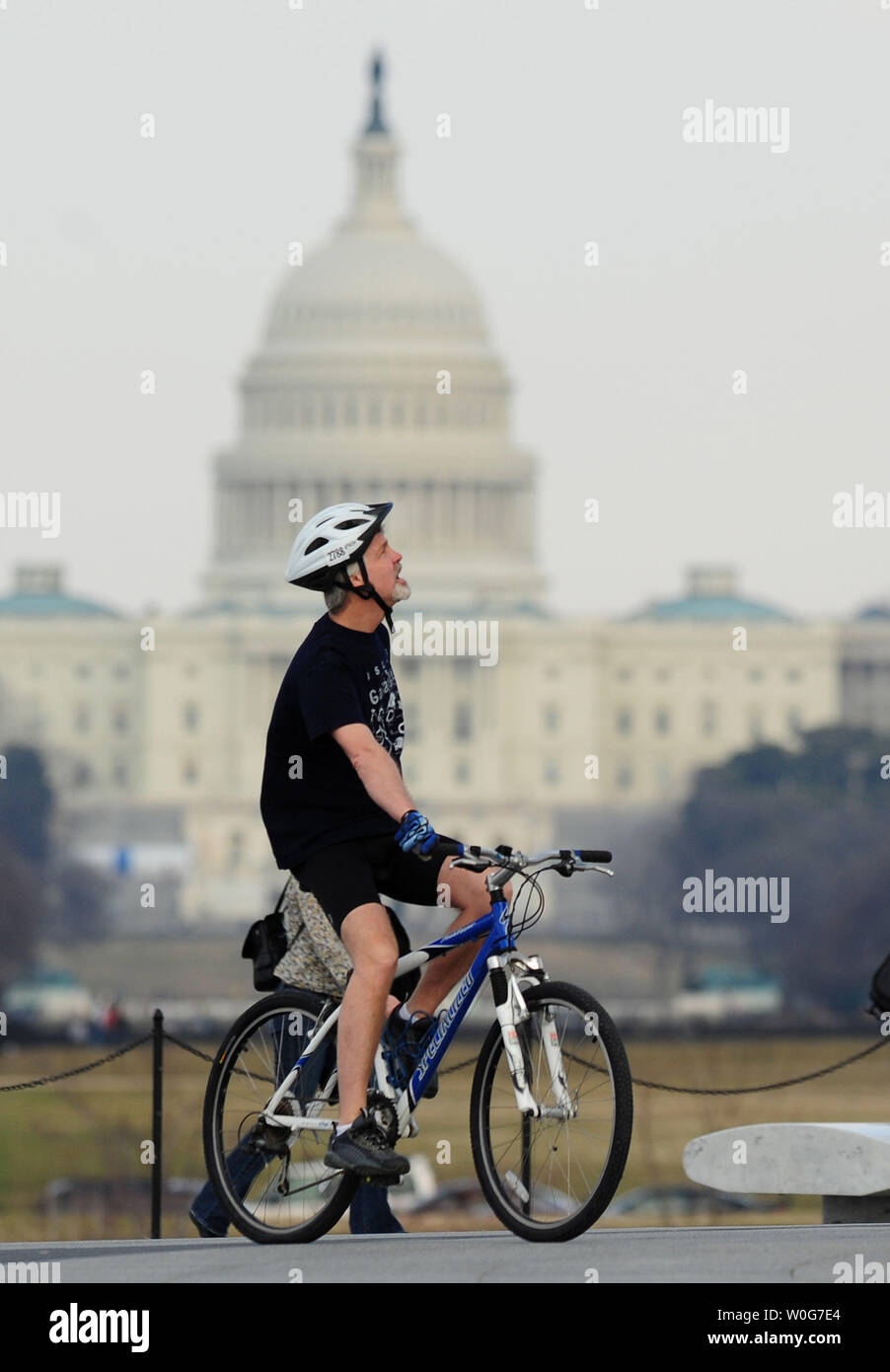 Ein Mann fährt mit dem Fahrrad auf der National Mall in Washington, als er den Vorteil einer ungewöhnlich warmen Wetter in der Gegend, 18. Februar 2011. Capitol der Nation sah Höhen im niedrigen 70s. UPI/Kevin Dietsch Stockfoto