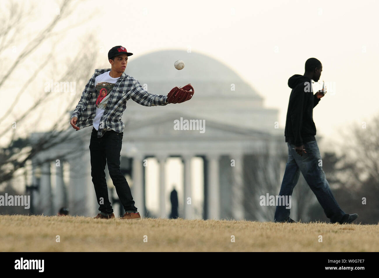 Ein Mann spielt Baseball auf der National Mall in Washington als die Gegend ungewöhnlich warmen Wetter, 18. Februar 2011. Capitol der Nation sah Höhen im niedrigen 70s. UPI/Kevin Dietsch Stockfoto