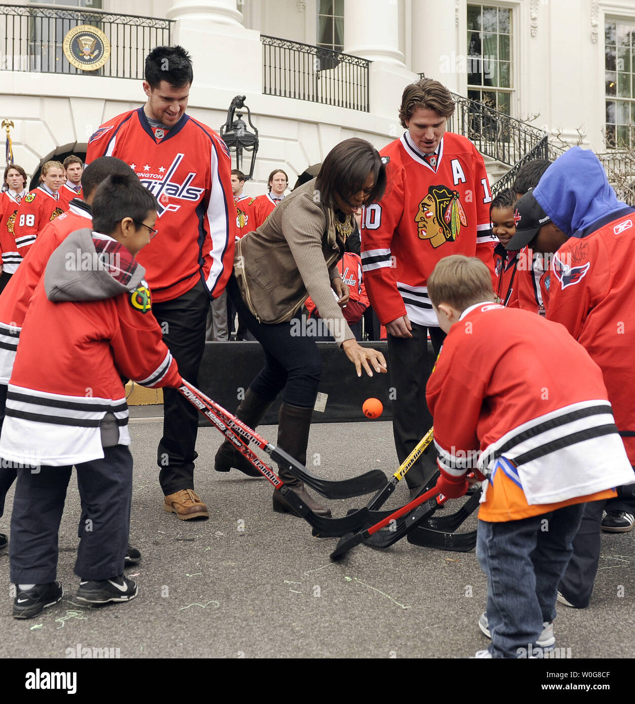 Washington Capitals defenseman Mike Green, First Lady Michelle Obama und Chicago Blackhawks, Patrick Sharp (L, R) eine Kugel weg von einem Street Hockey Spiel auf dem Südrasen des Weißen Hauses zu beginnen als Teil von Obamas "Let's Move" Programm in Washington am 11. März 2011 fallen. UPI/Roger L. Wollenberg. Stockfoto