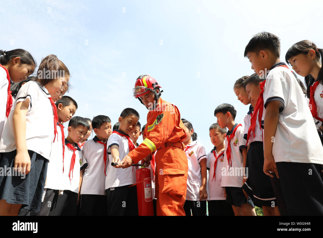 (190627) - BINZHOU, Juni 27, 2019 (Xinhua) - ein Feuerwehrmann lehrt Schüler einen Feuerlöscher an der Nr. 1 der Grundschule des Boxens County in Binzhou Stadt zu nutzen, der ostchinesischen Provinz Shandong, 27. Juni 2019. Sicherheit Bildung Aktivitäten sind in China gehalten, um zu helfen, das Bewusstsein der Studenten über die Sicherheit für einen sicheren Sommer Urlaub anheben. (Xinhua / Chen Bin) Stockfoto