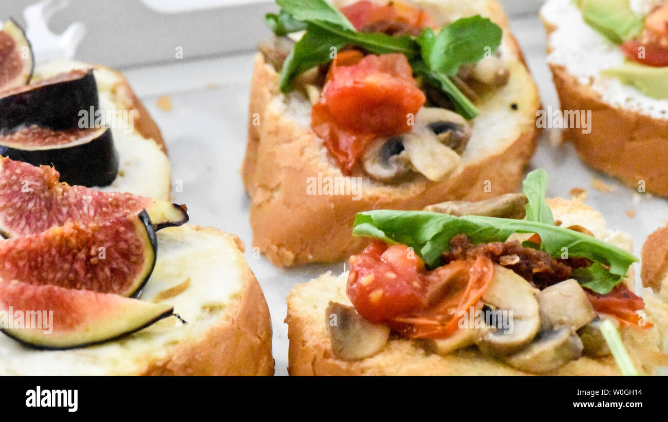 Sauber, gesund naschen Avocado, Tomate, Pilz und Feigen bereit, mit Kräuter, Blätter und ein kleines Stück Baguette serviert werden. Ideal bite Stockfoto