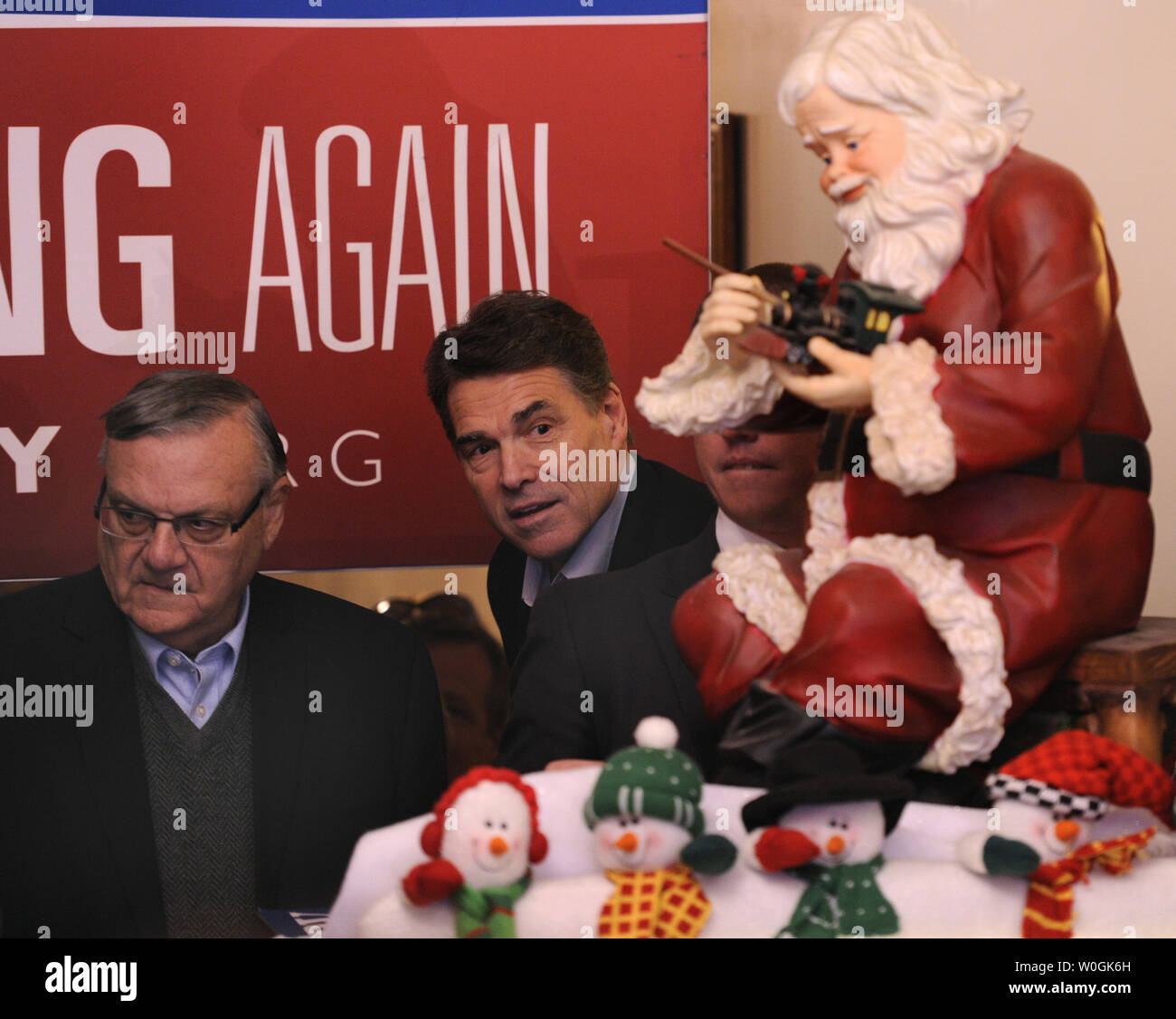 2012 Präsidentschaftskandidat der Republikaner und Texas reg. Rick Perry (R) sieht von hinten ein Weihnachtsmann zusammen mit Maricopa County (Arizona) Sheriff Joe Arpaio (L), wie er im Main Street Cafe ankommt, für eine Meet-and-Greet der Unterstützer, in Council Bluffs, Iowa, 27. Dezember 2011, im Voraus von Iowa's First-in-der-nation Caucuses, Januar 3,2012. UPI/Mike Theiler Stockfoto