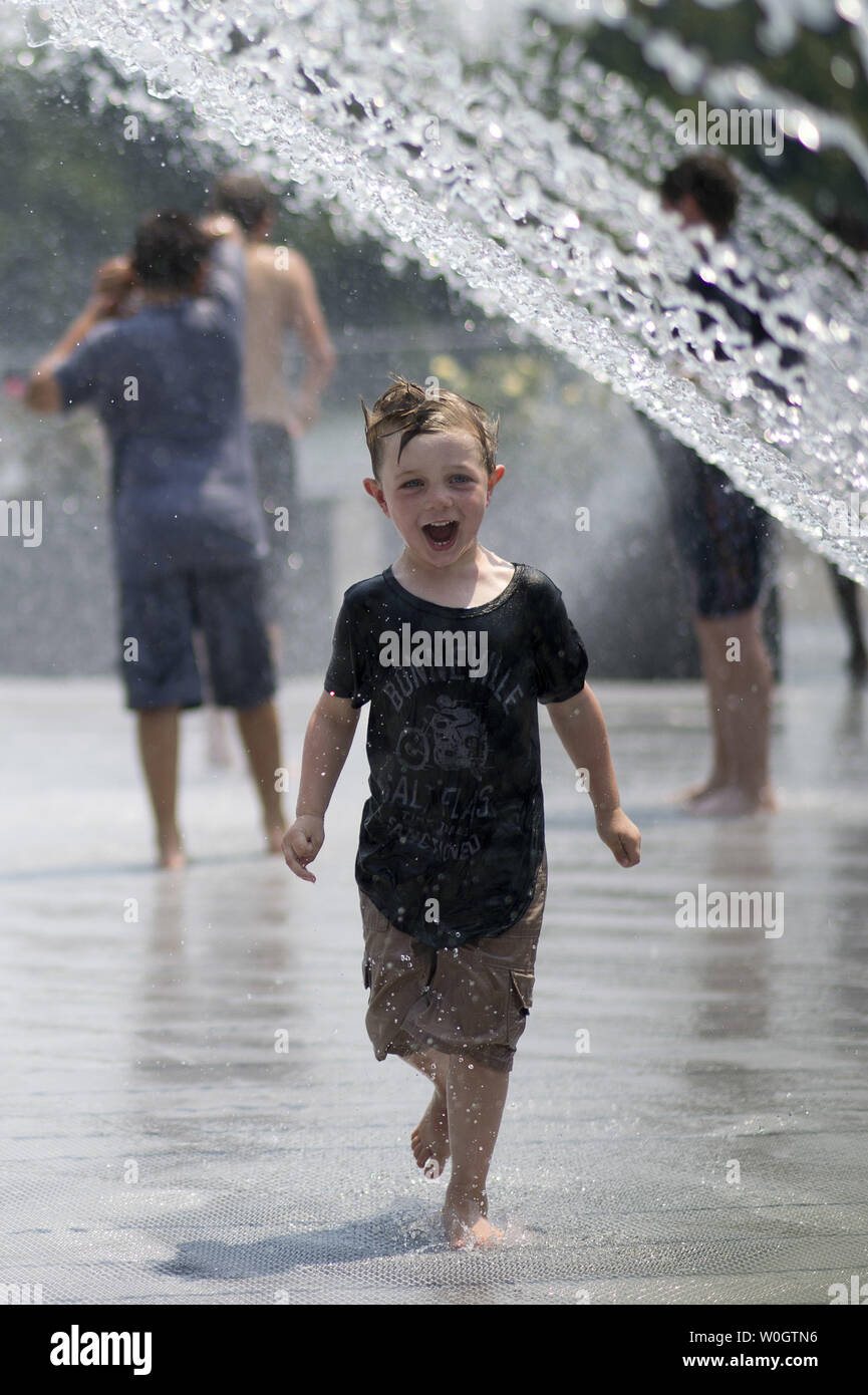 Ein Junge versucht zu schlagen, um die Wärme, wie Er kühlt sich in einem Brunnen an der Georgetown Waterfront am 29. Juni 2012 in Washington, D.C. Temperaturen erwartet werden rund 100 Grad durch das Wochenende zu schweben. UPI/Kevin Dietsch Stockfoto