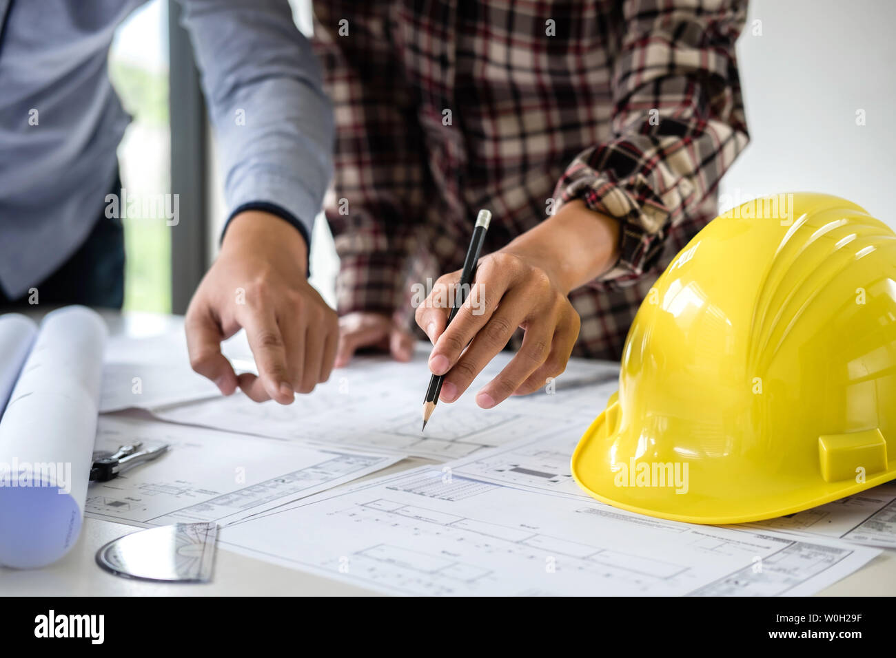 Construction Engineering oder Architekt einen Entwurf diskutieren beim Prüfen der Informationen zum Zeichnen und Skizzieren für architektonisches Projekt in wor Stockfoto