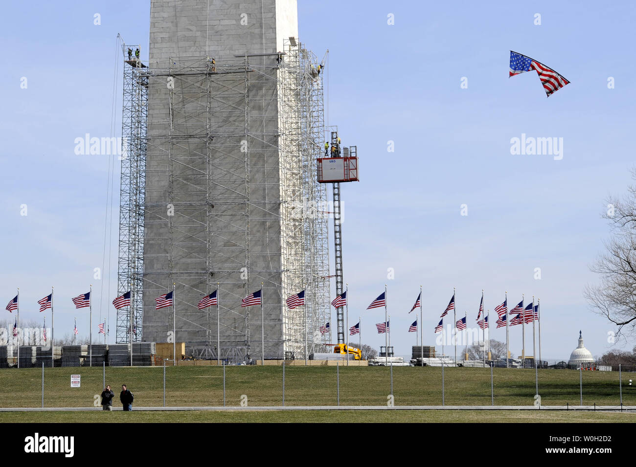 Das Washington Monument ist von Gerüsten als Besucher eine amerikanische Flagge Kite (R), 15. März 2013 fliegt gewickelt. Diese Arbeit beginnt Schäden, die sich aus der 5,8-Erdbeben im August 2011 in Washington, DC zu reparieren. Die 555-Fuß-Landmark hat geschlossen worden, da dann und Reparaturen, die voraussichtlich mehrere Monate in Anspruch nehmen, kostet 15 Millionen $. UPI/Mike Theiler Stockfoto