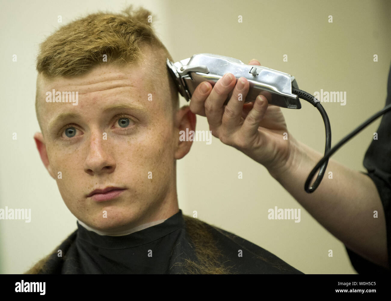 Einen eingehenden plebe hat seinen Kopf während der Induktion Tag rasiert an der US Naval Academy am 27. Juni in Annapolis, Maryland, 2013. Die Klasse von 2017 an der Marineakademie kamen ihre Sommer Ausbildung, die die Grundlage der Akademie die vier Laien-Jahr-professionellen Lehrplan zu beginnen. UPI/Kevin Dietsch Stockfoto