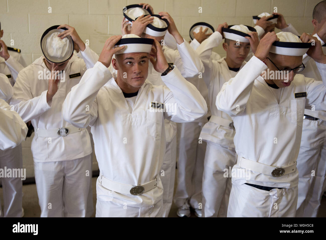 Eingehende plebes erlernen Sie, wie man richtig auf eine Abdeckung während der Induktion Tag an der US Naval Academy stellen am 27. Juni 2013 in Annapolis, Maryland. Die Klasse von 2017 an der Marineakademie kamen ihre Sommer Ausbildung, die die Grundlage der Akademie die vier Laien-Jahr-professionellen Lehrplan zu beginnen. UPI/Kevin Dietsch Stockfoto