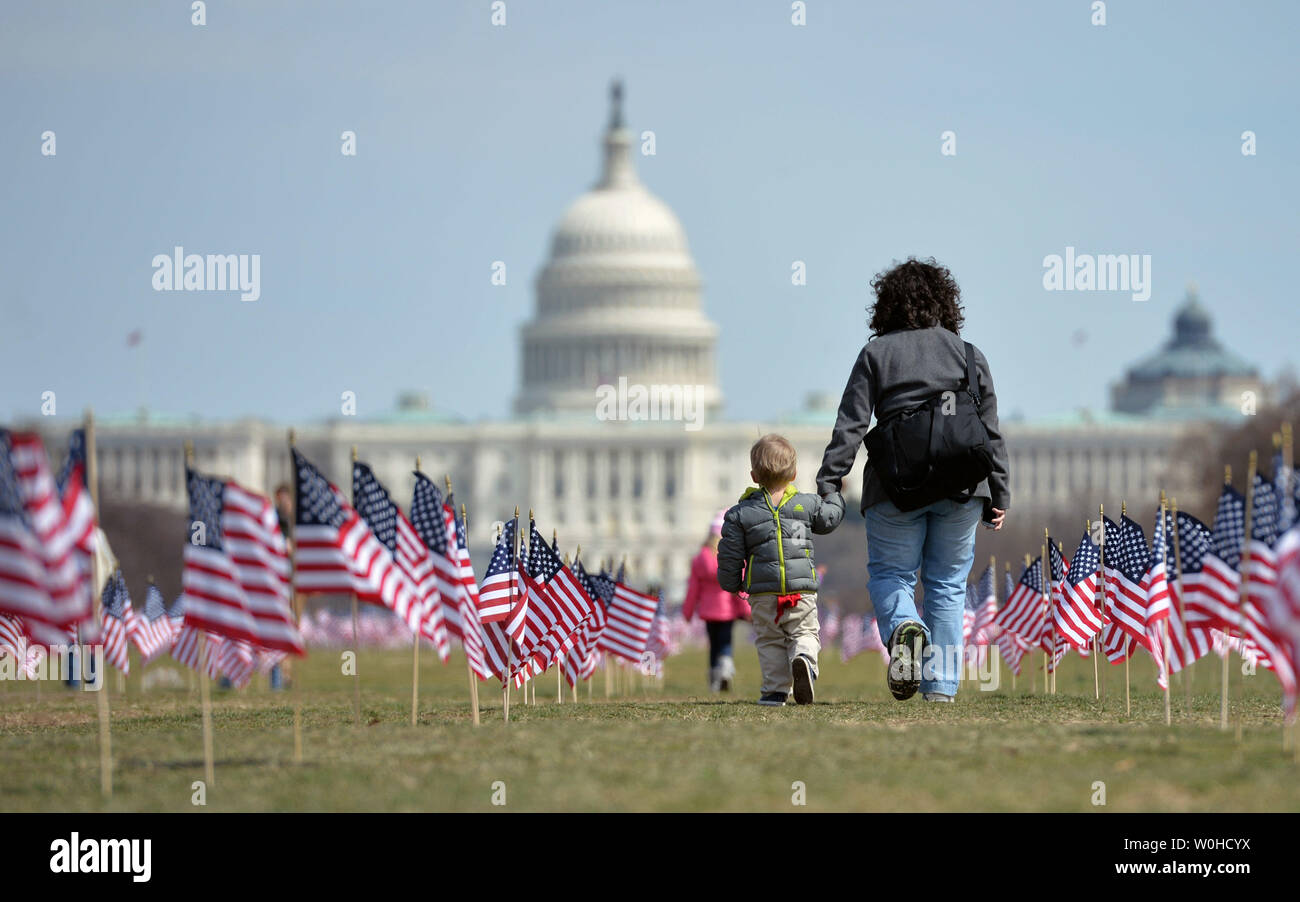 Eine Frau und Kind zu Fuß zwischen einigen der 1.892 amerikanische Flaggen auf der National Mall durch den Irak und Afghanistan Veteranen von Amerika, jede Fahne stellt eine der 1.892 Veteranen und Service Mitglieder, die Selbstmord begangen haben, in diesem Jahr in Washington, D.C., 27. März 2014. Das Denkmal ist Teil der "Wir haben Ihre Rückseite: IAVA Kampagne zur Bekämpfung der Selbstmord UPI/Kevin Dietsch Stockfoto