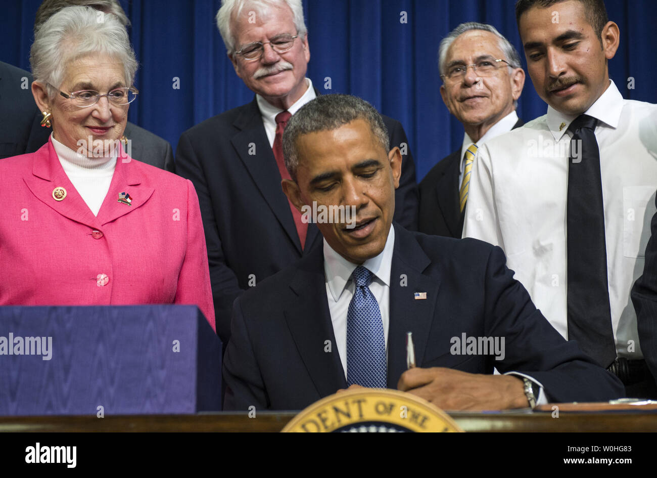 Von der Verwaltung Beamte flankiert, Mitglieder des Kongresses und eingeladene Gäste, Präsident Barack Obama unterzeichnet H.R. 803, die Belegschaft Innovation und Opportunity Act, im Süden Gericht Auditorium in das Eisenhower Executive Office Building in Washington DC am 22. Juli 2014. Das Gesetz soll die wirtschaftlichen Chancen für die Mittelschicht zu steigern. UPI/Pat Benic Stockfoto