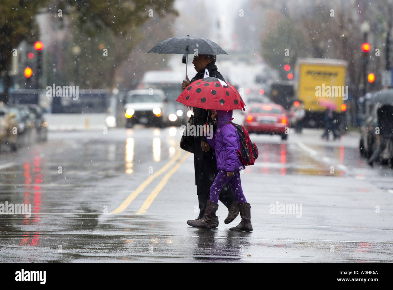 Fußgänger Kreuz 16. Straße als eine Mischung aus Schnee und Regen fallen in Washington, D.C. am 26. November 2014. Ein Thanksgiving storm System hat das Potential Verwüstung mit Urlaub Reiseplanung mit dem Potential, ein Fuß Schnee an einigen Stellen zu entleeren zu verursachen. UPI/Kevin Dietsch Stockfoto