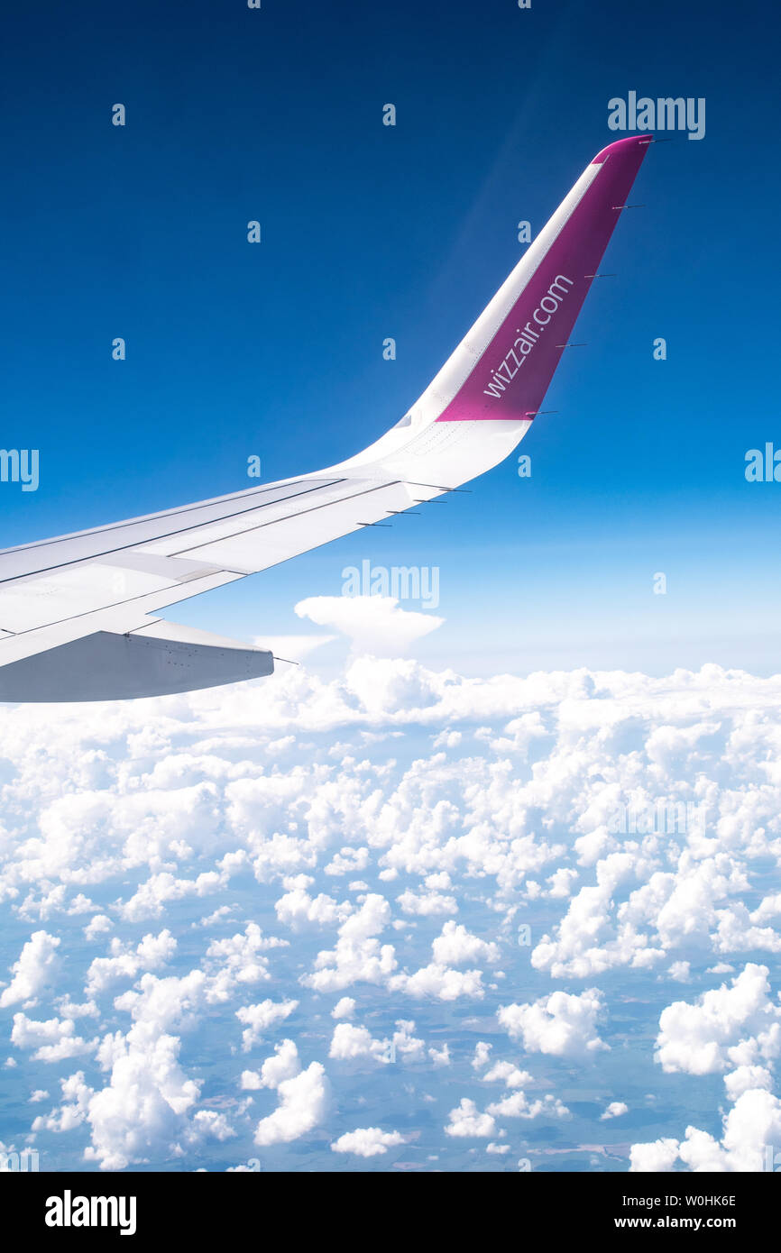 Wizzair Logo oder Marke auf dem Flügel, blauer Himmel mit den Wolken von der Ebene anzeigen Stockfoto