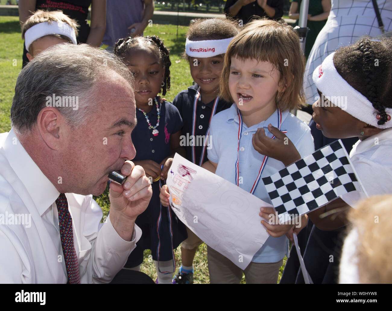 Senator Tim Kaine (D-Virginia.) spielt die Mundharmonika für Kinder während der 'Miles Ahead mit Früh Lernen" Veranstaltung von MomsRising.org und der National Women's Law Center (NWLC) vor dem Kapitol in Washington DC, 17. September 2015. Foto von Molly Riley/UPI Stockfoto