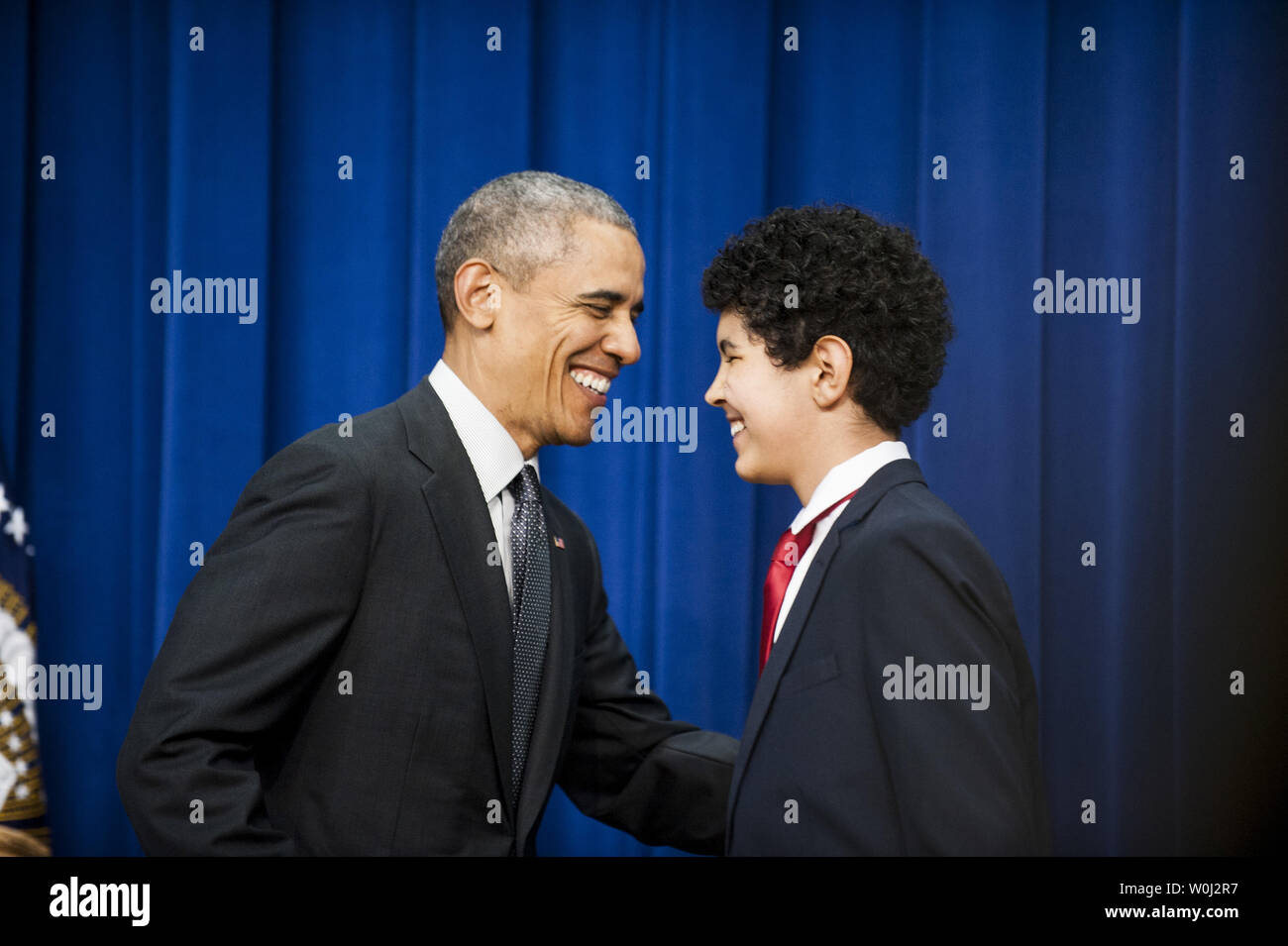 Präsident Barack Obama grüßt eingeführt von Antonio Martin, Alle - eine Honor Roll 8 Sortierer an der Kenmore an der mittleren Schule in Arlington, Virginia, nach Martin, ihn an einer Zeremonie eingeführt für die Unterzeichnung der jeder Schüler erfolgreich Handeln in Gesetz im Weißen Haus am 10. Dezember 2015 in Washington, D.C. Die parteiübergreifende Bill die Fortschritte in der elementaren und sekundären Bildung fortsetzen und Korrekturen zu der kein Kind hinzufügen Links hinter Tat durch Reduzierung der Über- prüfung und one-size-fits-all federal Mandate. Foto von Pete Marovich/UPI Stockfoto