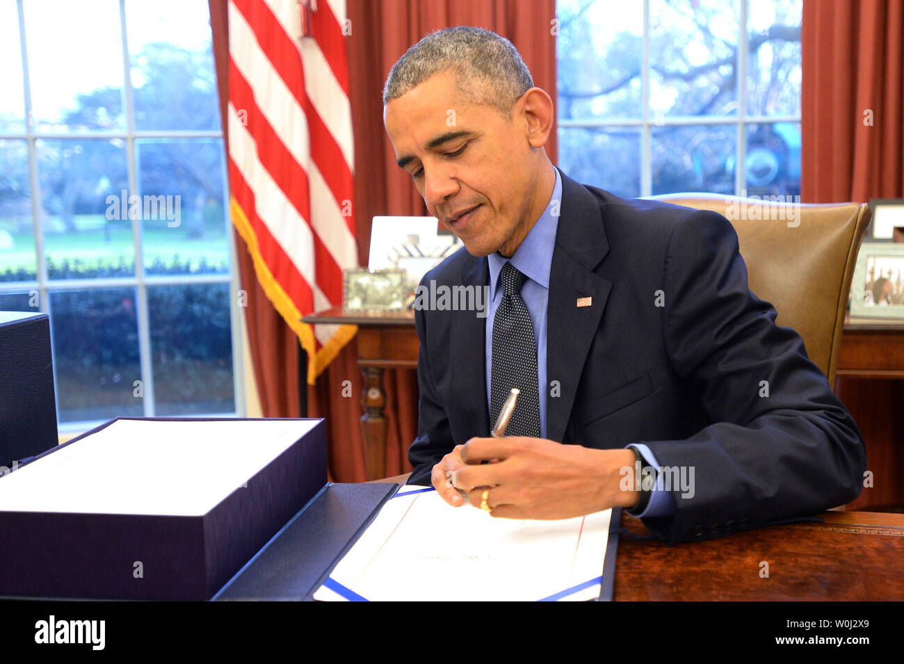 Us-Präsident Barack Obama unterzeichnet ein $ 1,15 Billionen ende Steuerpaket (Links) im Oval Office des Weißen Hauses in Washington, DC am 18. Dezember 2015. Die große Rechnung wurde vom Kongress früh am Tag genehmigt, und es enthält auch Steuererleichterungen für Unternehmen und Bürger mit niedrigem Einkommen. Foto von Pat Benic/UPI Stockfoto